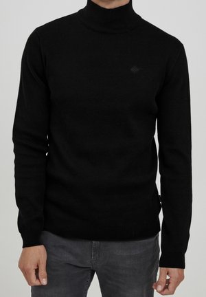 Pull à col roulé noir en tissu doux et texturé ; design ajusté avec des manches longues et des poignets et un ourlet côtelés ; détail de logo subtil.