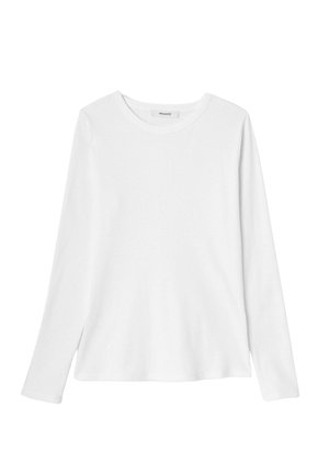 T-shirt blanc à manches longues en coton doux, doté d'un col rond et d'échancrures sur les côtés à l'ourlet pour plus de liberté de mouvement.