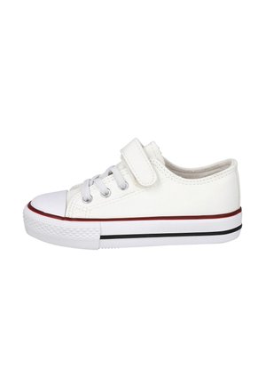 Zapatilla deportiva de lona blanca con puntera y suela de goma, cuenta con cordones elásticos, una tira de velcro y franjas contrastantes en rojo y negro en la suela.
