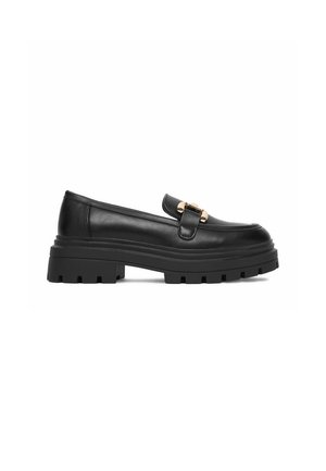 Schwarzer massiver Slipper mit dicker profillierter Sohle und goldfarbenem Metallschnallendetail am Riemen oben.