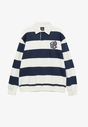 Rugby majica s dolgimi rokavi, z mornarsko modrimi in belimi vodoravnimi črtami, belim ovratnikom in vezenim monogramom na levi strani prsnega koša.