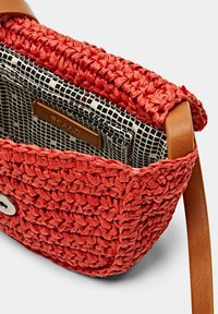 Borsa intrecciata rossa con una finitura testurizzata, dotata di una tracolla in pelle e di un rivestimento interno in tessuto a scacchi. Include una chiusura a scatto.