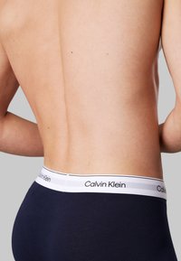 Blauwe katoenen onderbroek met een zachte, elastische tailleband voorzien van een witte streep en het 'Calvin Klein' logo in het zwart.