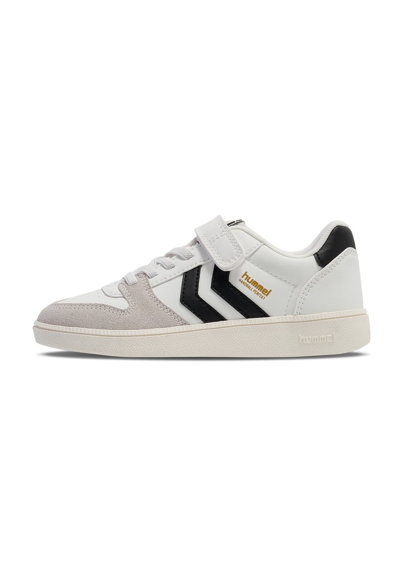 Sneaker bianco con dettagli in suede grigio, strisce nere e una fascia in velcro. Presenta una suola in gomma texturizzata e un logo del marchio dorato.