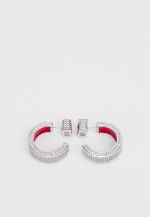 Hõbedased rõngakõrvarõngad punase sisevoodriga, millel on tekstureeritud pind ja väikesed selged kalliskivid välisserval.