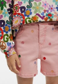 Roosa teksapükste lühikesed püksid, millel on värvikirevad lille- ja südame tikandid, regulaarne lõige ja kahekordne õmblusäär, koos mitmevärvilise mustriga sviitriga.