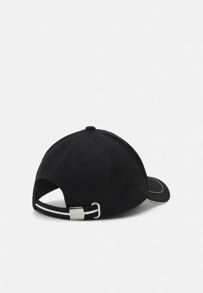 Casquette de baseball noire avec une visière courbée, fabriquée en coton. Présente des coutures blanches, un accent en métal argenté à l'arrière, et une sangle réglable rayée.