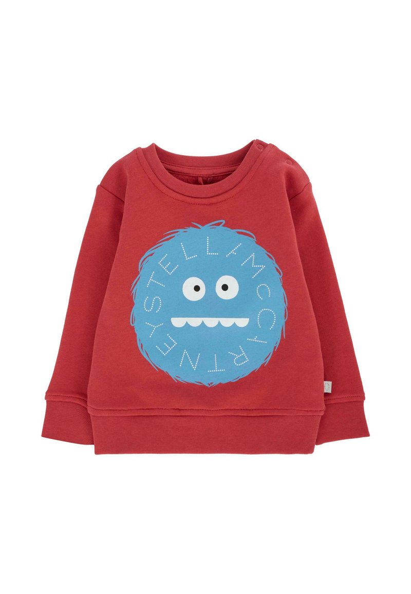 Czerwona bawełniana bluza z okrągłym graficznym wizerunkiem niebieskiego potwora z dużymi oczami i uśmiechniętą buzią, ozdobiona białymi literami wokół wzoru.