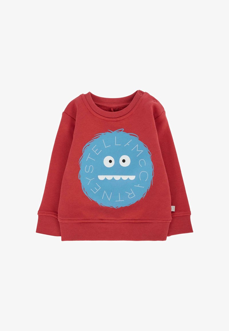 Czerwona bawełniana bluza z okrągłym graficznym wizerunkiem niebieskiego potwora z dużymi oczami i uśmiechniętą buzią, ozdobiona białymi literami wokół wzoru.