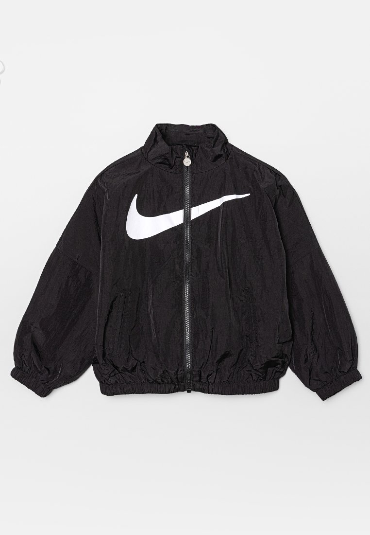 Veste coupe-vent Nike noire avec un col haut, des poignets élastiques et un ourlet élastiqué, mettant en avant un logo blanc prominent sur la poitrine. Fermeture à zip à l'avant.