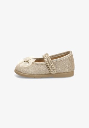 Zapato plano beige con brillo, con correa elástica fruncida y decoración de lazo translúcido en la punta, suela de goma, diseñado para un niño.