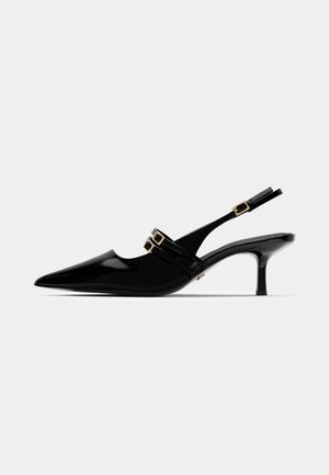 Juodos lakuotos odinės slingback kulnų bateliai, su smailiu pirštu, kuriuose yra dvigubi auksiniai sagtelės akcentai ir lieknas stiletto kulnas.