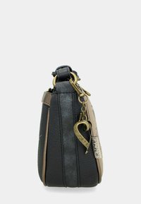 Schwarze und taupefarbene Lederhandtasche mit einer strukturierten Form, ausgestattet mit einem goldfarbenen Herzanhänger und Reißverschlusshardware. Glatte Textur, minimalistisches Design.