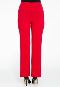 Rode, stretch stoffen broek met een rechte pijpdesign en elastische tailleband, gecombineerd met zwarte hoge hakken.