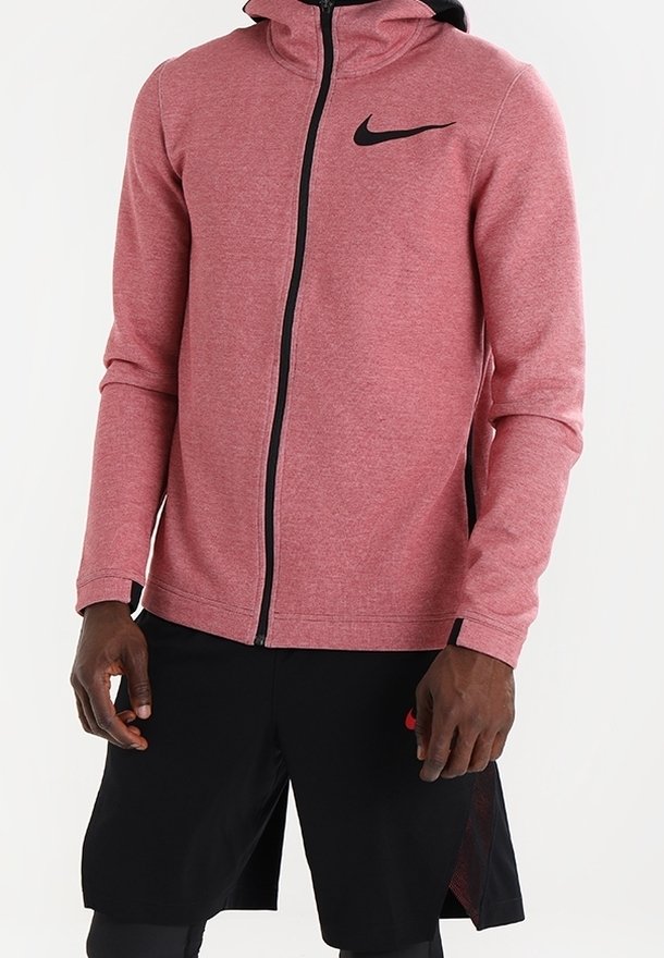 Rote Zip-Hoodie aus einem weichen, strukturierten Stoff mit schwarzen Akzenten, ausgestattet mit einem schwarzen Nike-Logo auf der Brust, kombiniert mit schwarzen Shorts.