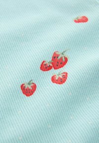 Vaaleansininen ribbineulospinta, jossa satunnaisesti punaisia mansikkakuviota; jokaisessa mansikassa on vihreät lehdet ja tummat siemenet yksityiskohtina.