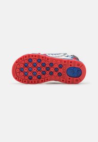 Rød gummisål med cirkulære mønstre, prydet med blå accenter. Overdelen inkluderer en blanding af hvide, blå og grå materialer.