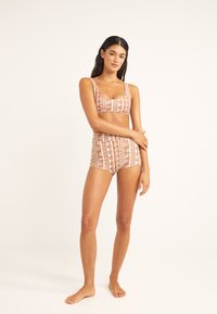 Bikini de dos piezas con estampado en marrón claro y crema, que presenta un escote cuadrado, parte inferior de talle alto y diseños florales en toda su superficie.