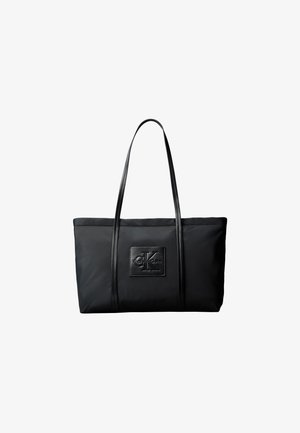 Borsa tote rettangolare nera con due manici lunghi e una toppa frontale con i loghi in rilievo "ck" e "Calvin Klein".