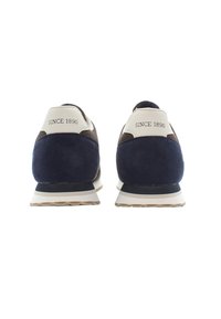 Sneakers in camoscio blu navy con accenti beige e dettagli in rete, dotati di una suola imbottita e con la scritta "DAL 1890" stampata sulla linguetta del tallone.