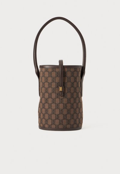 Brown bucket bag with dark geometric pattern, dark leather trim, single top handle, and gold-tone clasp closure on front strap.