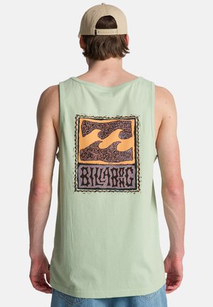 Camiseta sin mangas verde menta con un gráfico estampado en la parte trasera que muestra olas en tonos naranja y negro, combinada con una gorra beige.