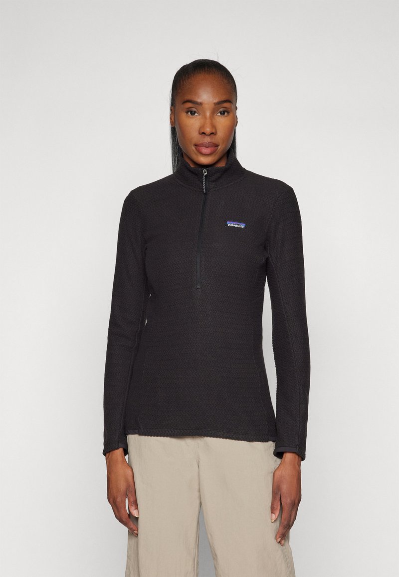 Black quarter-zip pullover, textured fabric, long sleeves, fitted design, featuring a small brand logo on the left chest.
