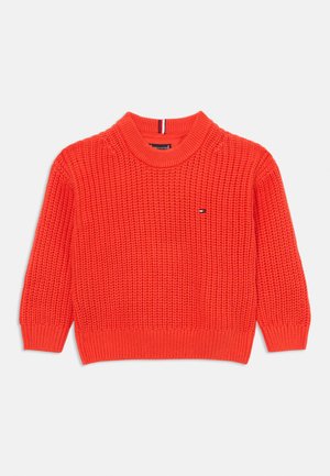 Suéter de punto en color naranja brillante, con un patrón texturizado, mangas cortas acanaladas y un cuello redondo. Incluye un pequeño detalle de logo.