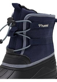 Marineblauwe waterdichte laars met textiele bovenkant, grijze accenten, zwarte rubberen zool en een verstelbaar vetersysteem voor een veilige pasvorm.