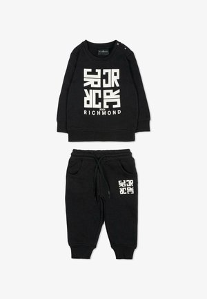 Ensemble en coton noir comprenant un sweat-shirt et un pantalon de jogging, agrémenté d'un texte graphique en blanc. Le sweat-shirt a un col rond et des boutons-pression aux épaules ; le pantalon de jogging possède des poches.