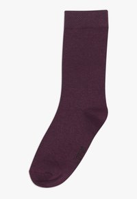 Lila Socke aus glattem Stoff, mit einem strukturierten Bündchen, in mittellanger Wadenhöhe, und schlichtem Design mit einem dezenten Logo nahe der Zehen.