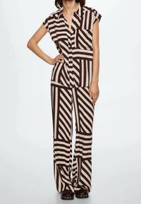 Brown and beige striped shirt with a collar and short sleeves paired with matching wide-leg pants, featuring a geometric pattern and relaxed fit.