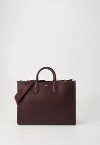 bolso de mano de cuero burdeos con dos asas superiores, correa de hombro desmontable y detalle de logotipo dorado en el frente. Textura lisa, diseño estructurado.