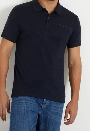 Granatowa koszulka polo z klasycznym kołnierzykiem, krótkimi rękawami i subtelnym logo marki na piersi. Wykonana z gładkiej bawełnianej tkaniny.