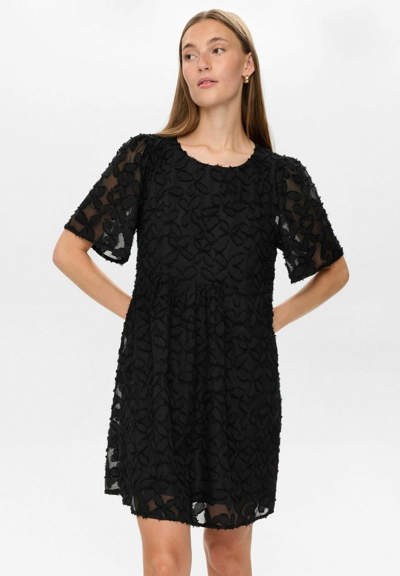 Rochie neagră cu mâneci scurte, broderie florală, suprapunere semi-transparentă, decolteu rotund, croială lejeră și țesătură texturată cu o siluetă stratificată.