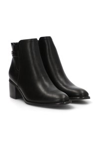 Botas de tobillo de cuero negro con punta redonda, un tacón bajo en bloque y una correa decorativa con un acento metálico en el tobillo. Textura suave.
