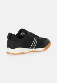 Scarpe da atletica nere con tomaia in rete, dettagli con strisce bianche, suola bianca imbottita e suola esterna in gomma marrone, progettate per comfort e supporto.