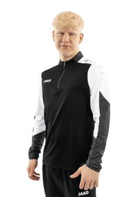 Maglia sportiva nera a maniche lunghe con dettagli bianchi, colletto a zip quarti e logo. Realizzata in un tessuto leggero, presenta una finitura testurizzata e maniche a contrasto.