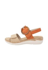 Sandale beige et orange avec un accent circulaire, bride Velcro, semelle texturée et une base compensée blanche et ergonomique.