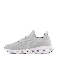 Des chaussures de sport grises avec une tige en tricot, une texture perforée et une semelle blanche rembourrée avec des canaux distincts pour plus de flexibilité.