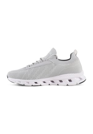 Des chaussures de sport grises avec une tige en tricot, une texture perforée et une semelle blanche rembourrée avec des canaux distincts pour plus de flexibilité.