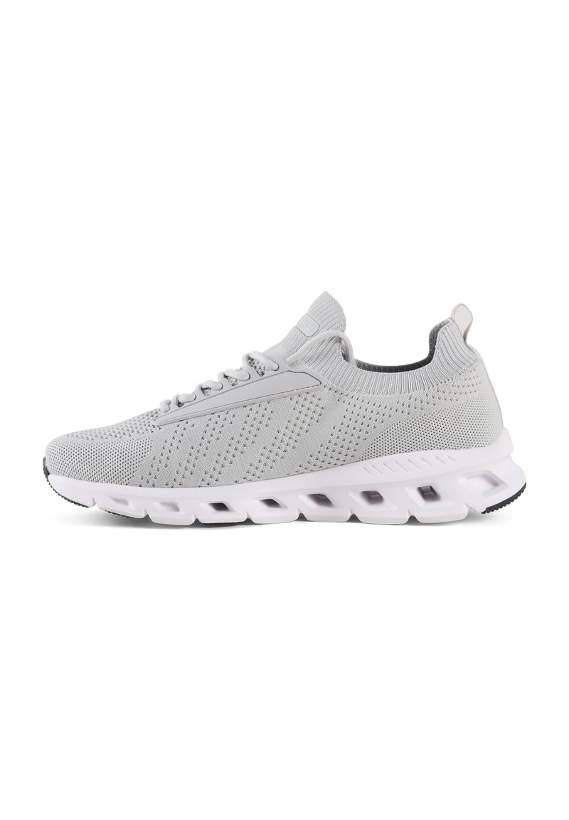 Des chaussures de sport grises avec une tige en tricot, une texture perforée et une semelle blanche rembourrée avec des canaux distincts pour plus de flexibilité.
