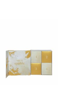 Boîte cadeau comportant quatre compartiments numérotés avec un design blanc et doré. Le couvercle indique "IL EST TEMPS DE briller" en texte doré.