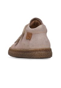 Světle růžové kotníkové boty vyrobené z měkkého materiálu s texturovaným povrchem, se hnědou gumovou podrážkou a štítkem s logem na boku.