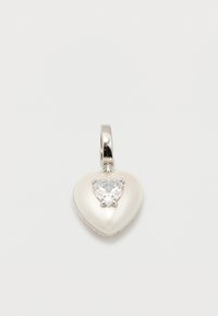 Ασημένιο μενταγιόν σε σχήμα καρδιάς με μια καθαρή πολύτιμη πέτρα κομμένη σε σχήμα καρδιάς στο κέντρο και μια λεία, γυαλιστερή επιφάνεια με φόντο το λευκό.