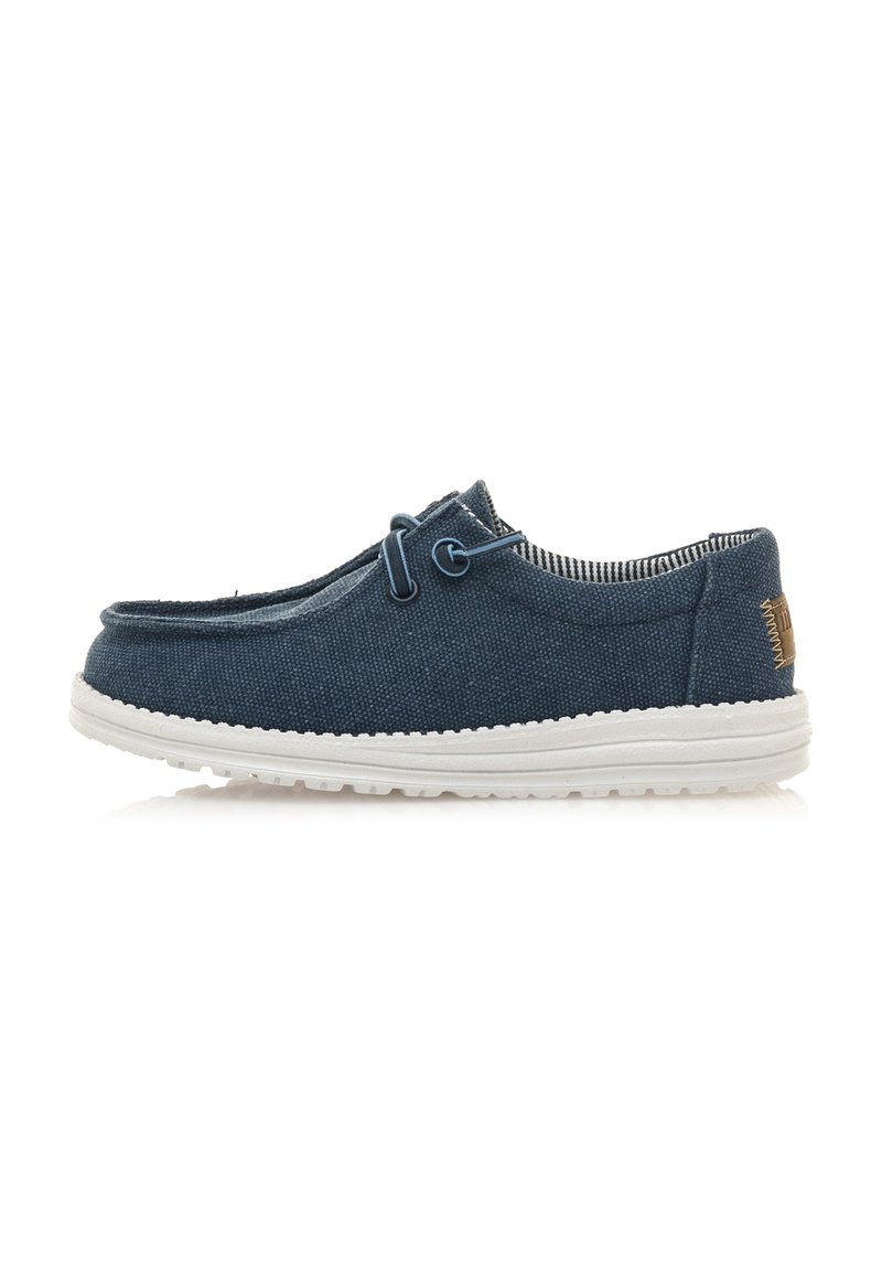 Scarpa slip-on in tessuto blu con finitura testurizzata, suola in gomma bianca e cuciture decorative. Presenta un dettaglio di lacci decorativi sul davanti.