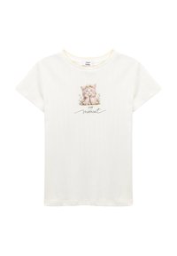 Hvid t-shirt med korte ærmer, med et kattebillede omgivet af blomsterdekorationer og teksten "LEV øjeblikket" i sort. Tekstureret stof.