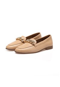 Mocasines de cuero beige con una textura suave, punta afilada, tacón bajo y un hardware decorativo de cadena dorada en la parte frontal.