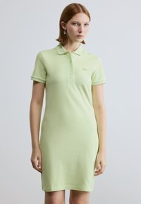 Robe polo vert clair à manches courtes, dotée d'un col et d'une patte de boutonnage, fabriquée en coton doux. Logo brodé sur la poitrine.