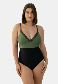 Maillot de bain une pièce avec un décolleté en V profond, en haut vert olive avec des accents noirs, et un bas noir, fabriqué en tissu extensible avec une texture lisse.